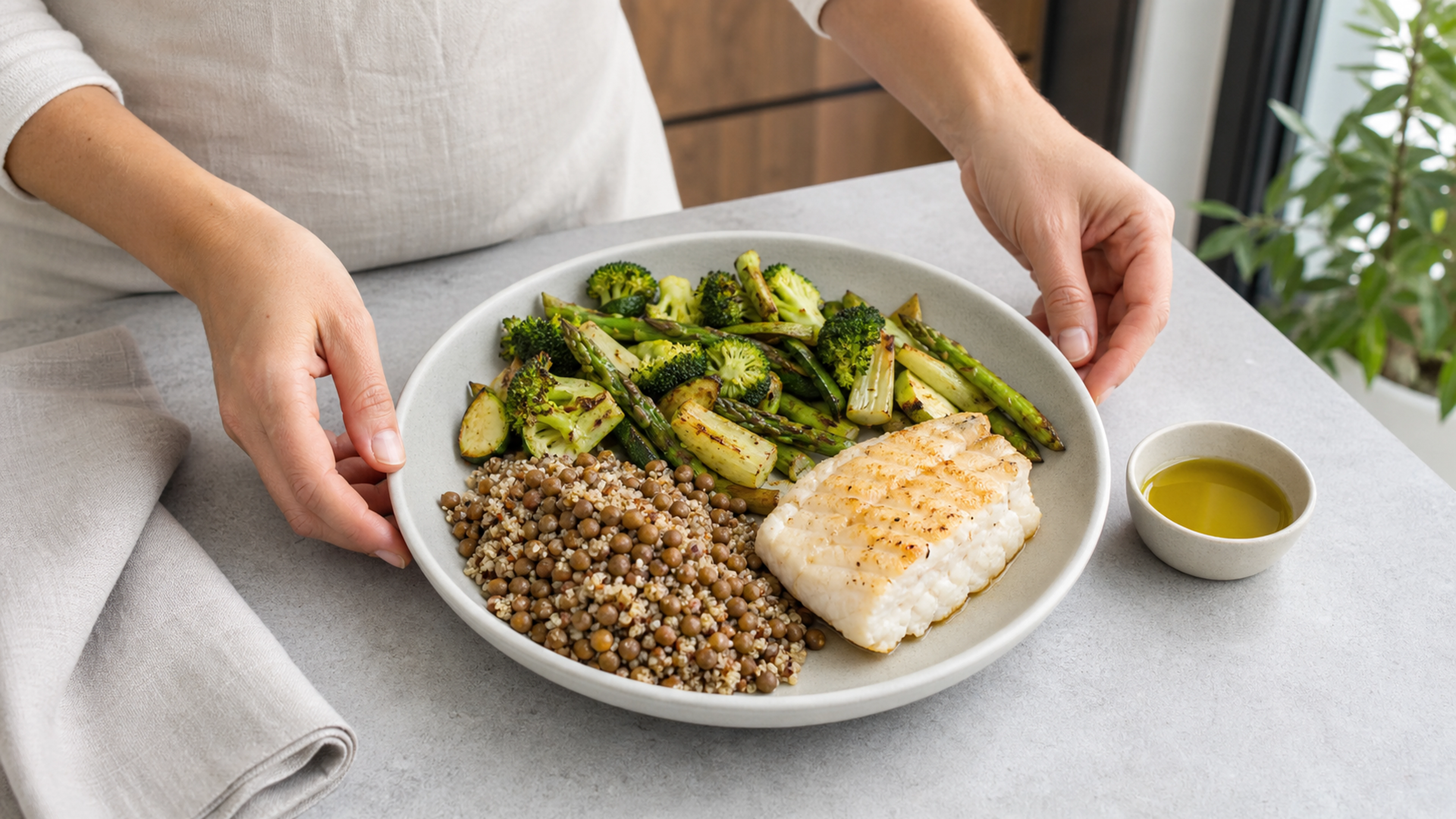 Assiette équilibrée avec légumes verts, lentilles, quinoa et poisson blanc dans une cuisine lumineuse